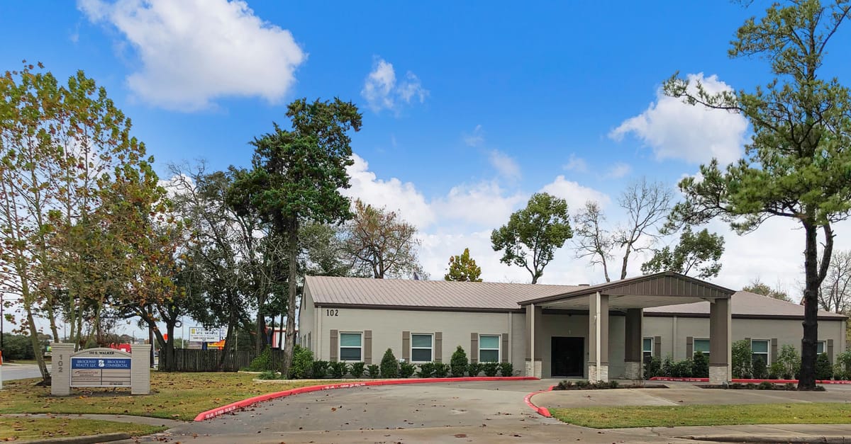 Professional Building — 102 E Walker St, League City, TX The Professional Building at 102 E Walker Street, League City — single-story professional office building with covered entry and monument sign